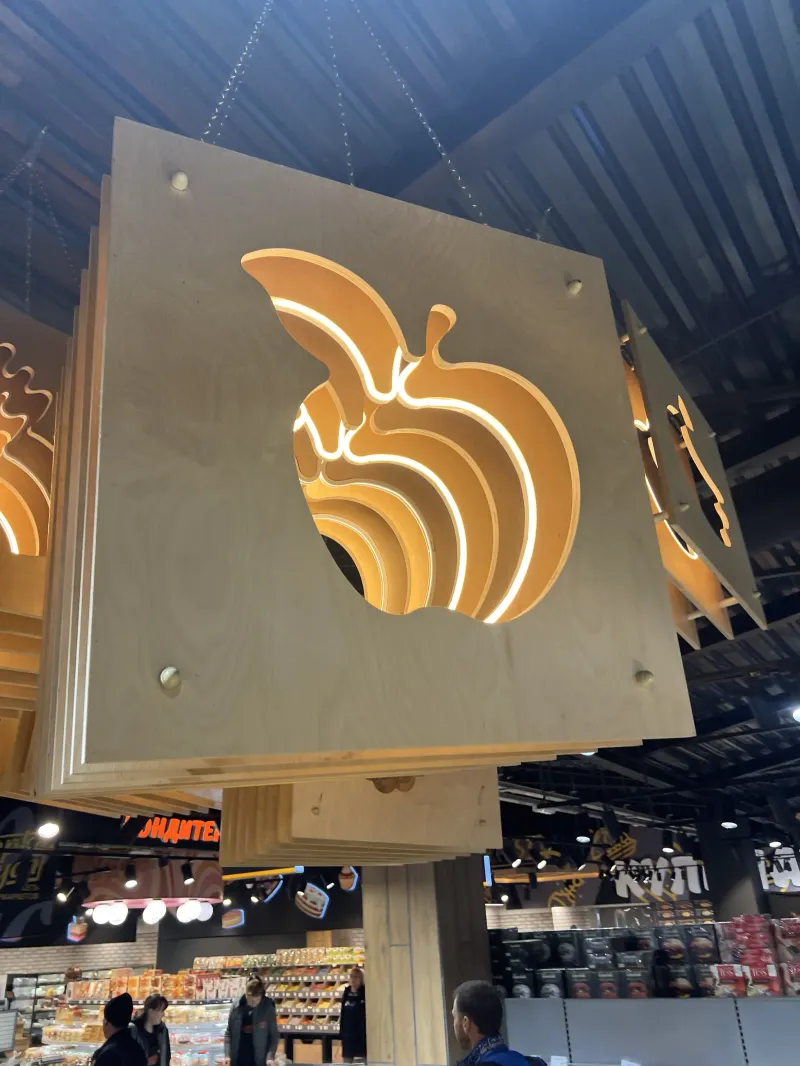 Suspended apple-shaped timber feature in a food shop
